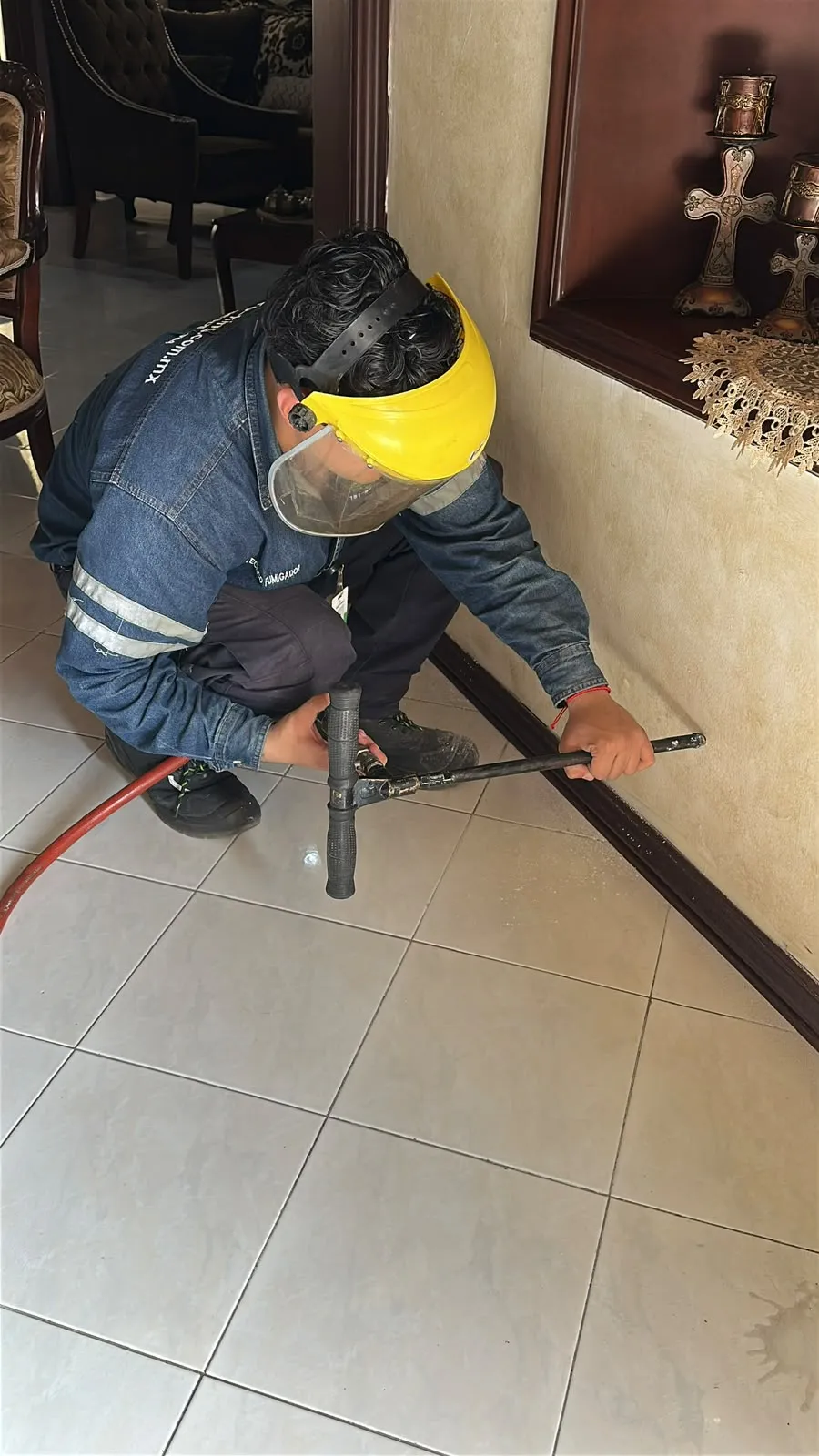 Técnico de Marro-King con careta perforando junto al zoclo de una casa para aplicar tratamiento